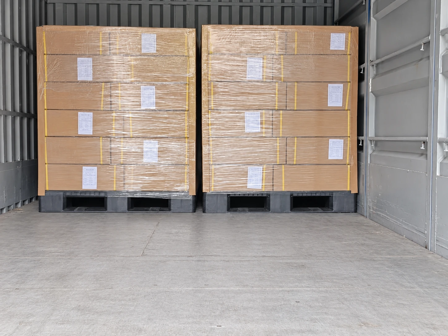 Wrapped cartons on pallets inside a shipping container